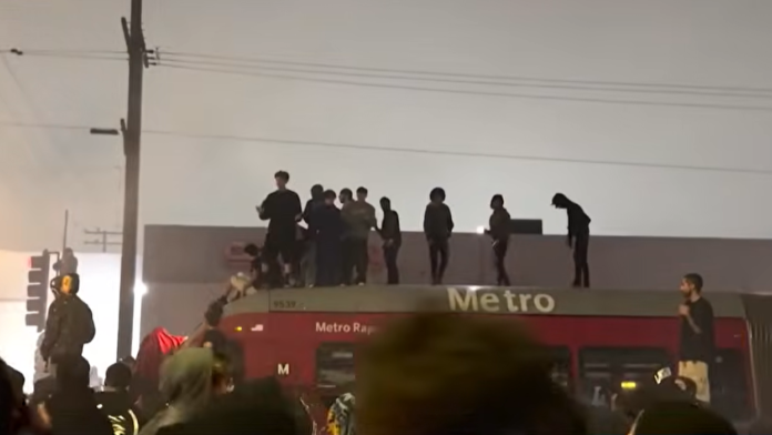 Street takeover crowd swarms L.A. Metro bus, vandalizes vehicle